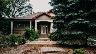 Home with porch, steps, and landscaping. Photo